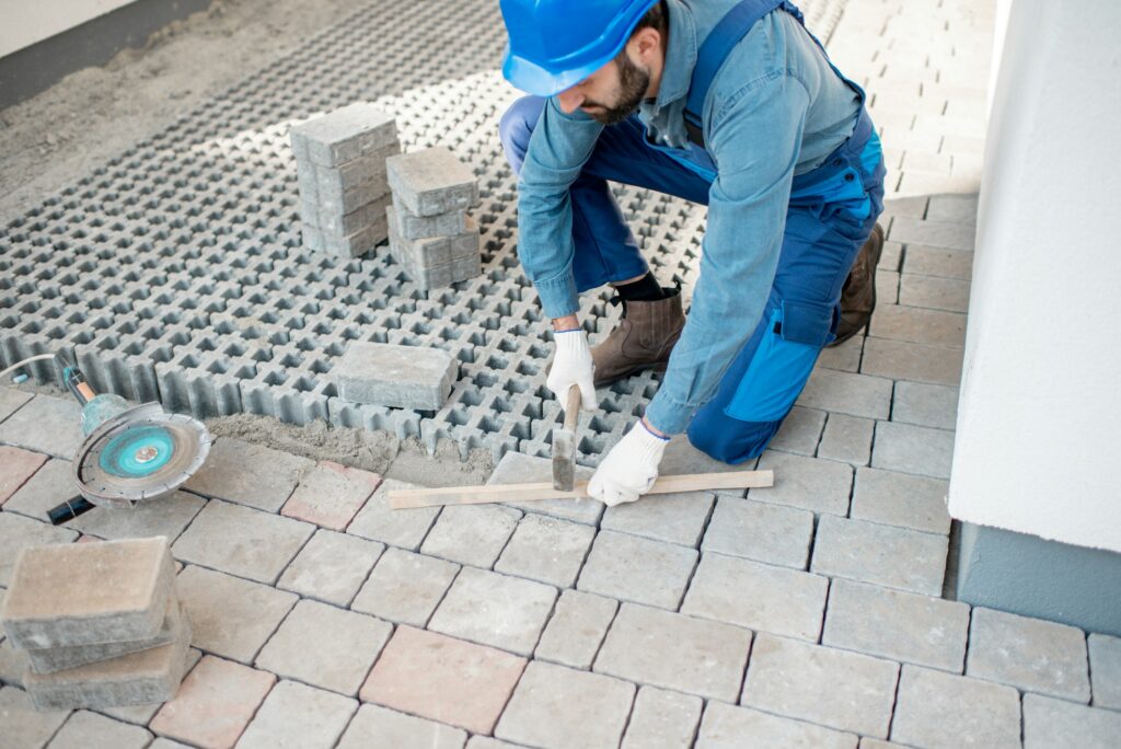 Builder laying paving tiles